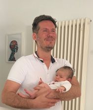 Matthias Frank mit Säugling nach der Behandlung
